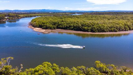 Beautiful famous Tinchi Tamba Wetlands, Bald Hills seen from above, spectacular wide river and speedboat. Shot from a drone, Brisbane, Queensland, Australia. 