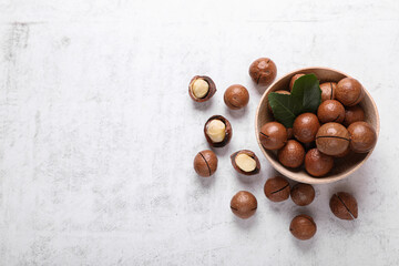 Delicious organic Macadamia nuts on white textured table, flat lay. Space for text