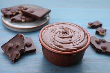 Tasty homemade paste and pieces of chocolate on light blue wooden table, closeup