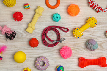 Flat lay composition with dog leash and toys on white wooden background
