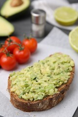 Delicious sandwich with guacamole on parchment paper, closeup