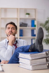 Young male employee sitting at workplace