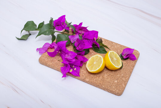 Flore de bugambilia y rodajas de lim&oacute;n cobre superficie de m&aacute;rmol 