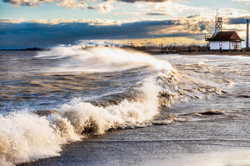 late afternoon sun on dramatic wind and  waves  breaking on a beach in toronto