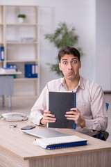 Fototapeta premium Young male employee working in the office