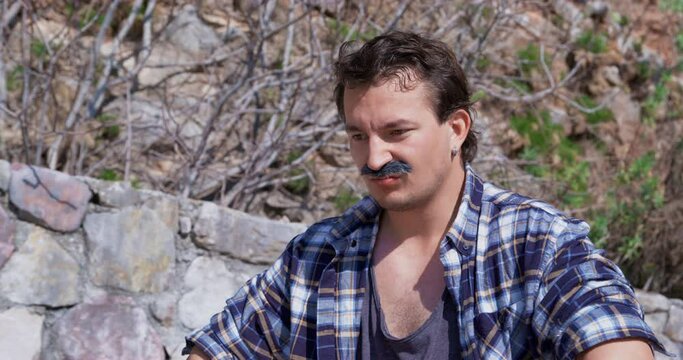 Mysterious salesman with mustache tries to scoff at tourists customers. Male seller with furious expression tries to argue about price for fruits