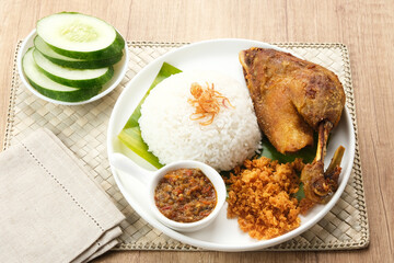 Bebek Goreng Kremes, served with chili sauce (sambal) and cucumber. Indonesian food
