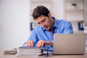 Young male employee and too much work in the office