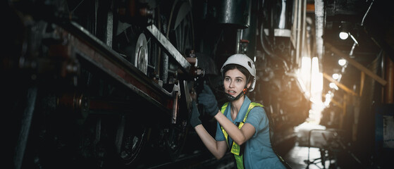 Fototapeta na wymiar Portrait of Industrial engineer are working in the factory. Worker helping to repair and inspect the machine's readiness. Mechanical technicians are maintaining the engine in the train garage.