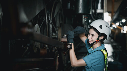Engineer are working in the factory. Worker helping to repair and inspect the machine's readiness. Mechanical technicians are maintaining the engine in the train garage that is malfunctioning.