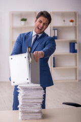 Young male employee unhappy with excessive work in the office