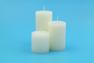 Fototapeta na wymiar Three white candles on blue background. 