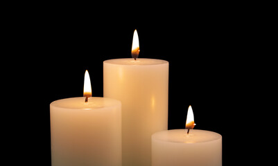 Fototapeta na wymiar Burning candles isolated on black background. Copy space for text. 