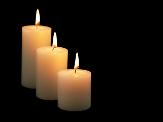 Fototapeta na wymiar Three burning candles isolated on black background. Room for text.