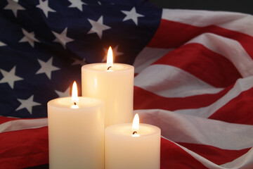 Fototapeta na wymiar Burning candles on United States flag background. Memorial day concept. 