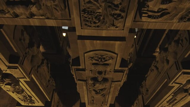 Descending shot with tilt up of the chronicle of Georgia statues at night