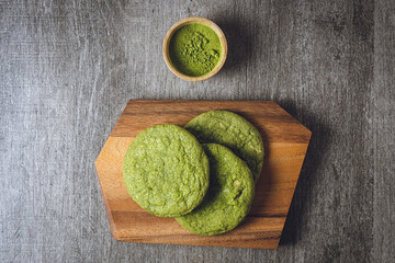 Matcha cookies with macadamia nuts and white chocolate chips on a dark wooden table - 588965983