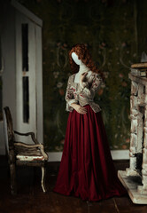 Fototapeta na wymiar A composite image of a mannequin with human hands standing in a dolls house room