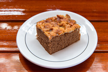 Chocolate cake on a white plate look appetizing placed on a wooden table