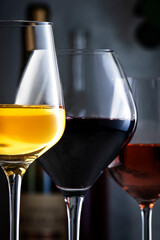 Wine glasses ans bottles assortment. Red, white, rose wines on gray table background. Wine bar, shop, tasting concept. Close-up