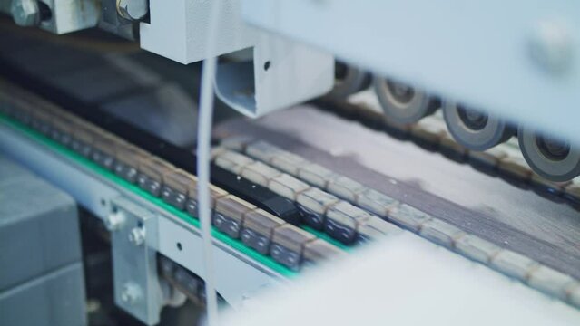 Laminated plywood furniture detail on a conveyor belt. Automated plywood laminating machine in a furniture manufacturing factory, capturing the intricate process of construction and robotics.