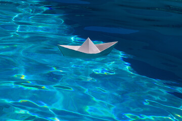 Paper ship. Paper boat in blue sea background. Tourism, travel dreams vacation holiday. Blue water background.