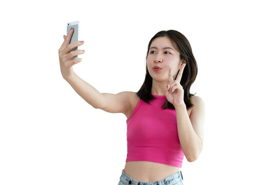 Cheerful young woman taking a selfie with a mobile phone and raising two fingers, Portrait of happy girl with bright face isolated on PNG, Take a photo, PNG file.