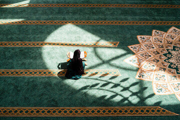 A Muslim woman praying inside the mosque.