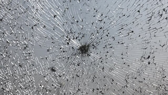 Broken windshield of a car close-up as a background. Texture broken glass with cracks.