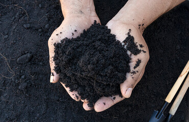 Hand holdind soil. Fertile loam soil suitable for planting, soil texture background.Top view of fresh soil. Concept of global pollution, World Soil Day