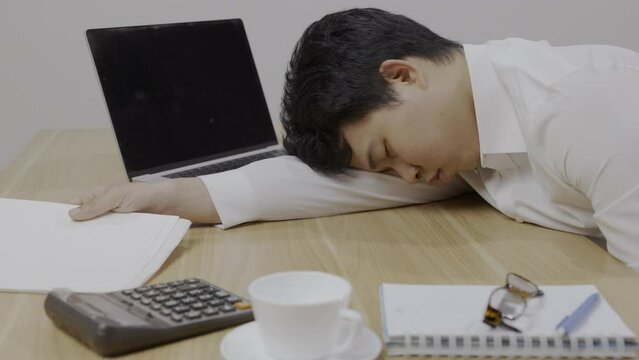 Man with narcolepsy is fall asleep on office desk..Narcolepsy is a sleep disorder that makes people very drowsy during the day.