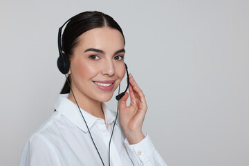 Hotline operator with modern headset on light grey background, space for text. Customer support