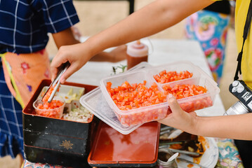 Hand holding a tray of cube sliced tomatoes for cooking, organic lifestyle and vegan concept.