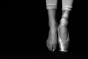 Ballerina in pointe shoe dancing, closeup with space for text. Black and white effect