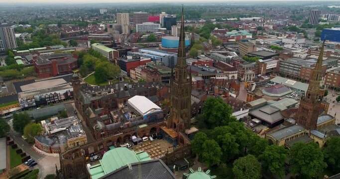 Aerial pull-back shot above Coventry Cathedral revealing the old ruins.