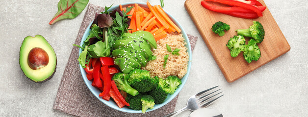 Delicious vegan bowl with bell pepper, avocado and broccoli on grey table, flat lay. Banner design