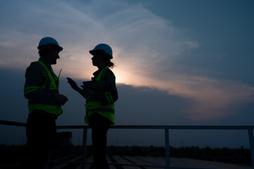 A team of electrical engineers inspecting solar panels in a hundred acres of grass on the rooftop...
