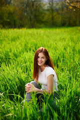 vertical photo of a woman sitting in the grass