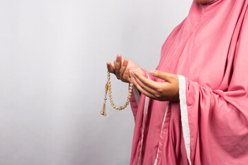 Islamic moslem woman praying with crystal tasbih wearing traditional dress
