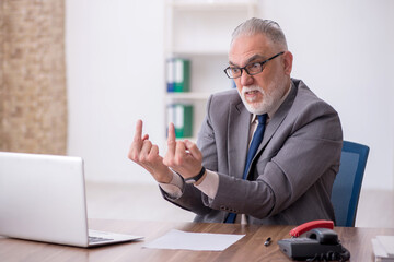 Old male employee working in the office