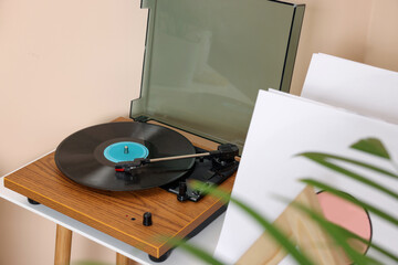 Stylish turntable with vinyl record on white table indoors