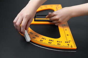 Woman drawing with chalk and protractor on blackboard, closeup