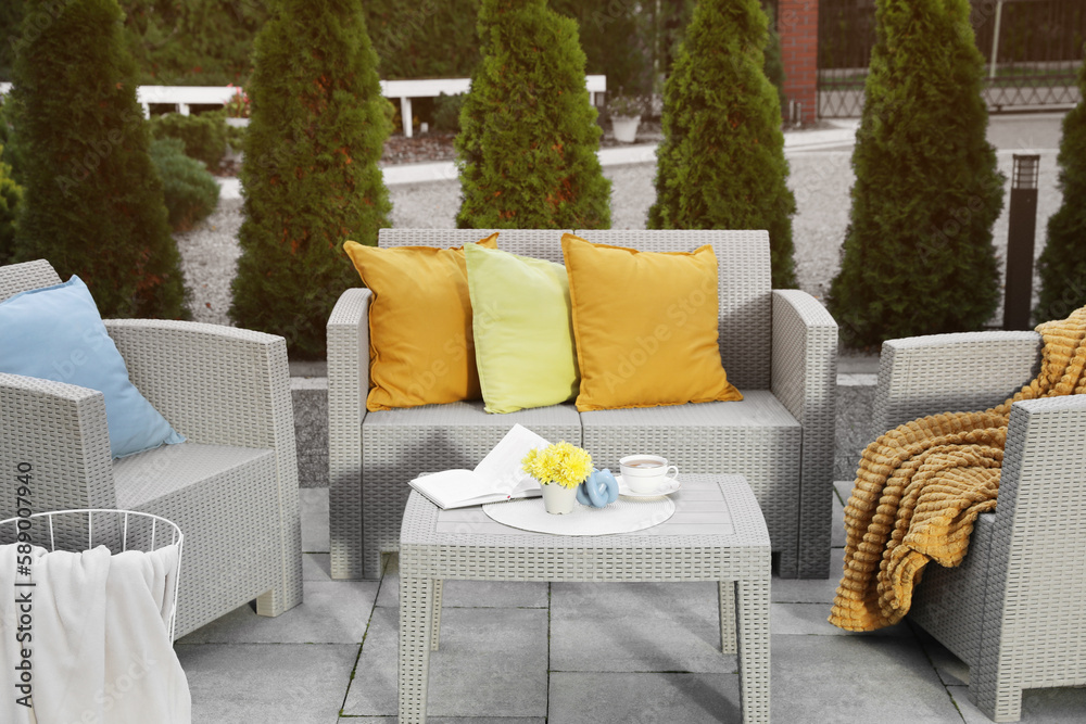 Sticker Beautiful rattan garden furniture, soft pillows and different decor elements in backyard