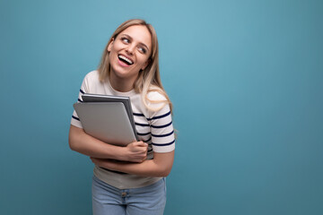 Fototapeta premium confident young woman student with a laptop in her hands on a blue isolated background with copy space
