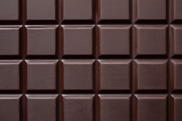 Delicious dark chocolate bar as background, top view