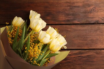 Bouquet with beautiful tulips and mimosa flowers on wooden table, top view. Space for text
