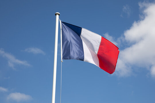 French flag of France waving over a blue sky