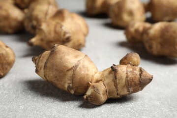 Fototapeta premium Many Jerusalem artichokes on light grey table, closeup