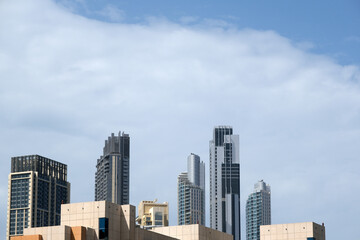 Fototapeta premium Futuristic and modern commercial and residential highrise tower skyscraper architecture with glass facades and clean lines in downtown Dubai, United Arab Emirates for millionaires and high society
