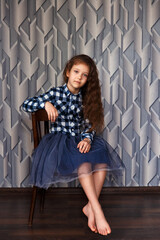 Fototapeta premium portrait of a young girl in the studio on an abstract background, portrait of a guy sitting on a chair, studio shooting
